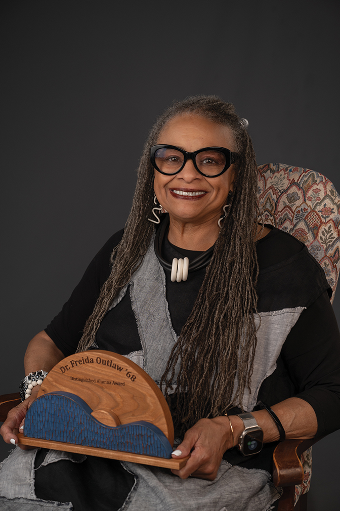 Portrait of Dr. Frieda Outlaw '68 holding her alumni award.