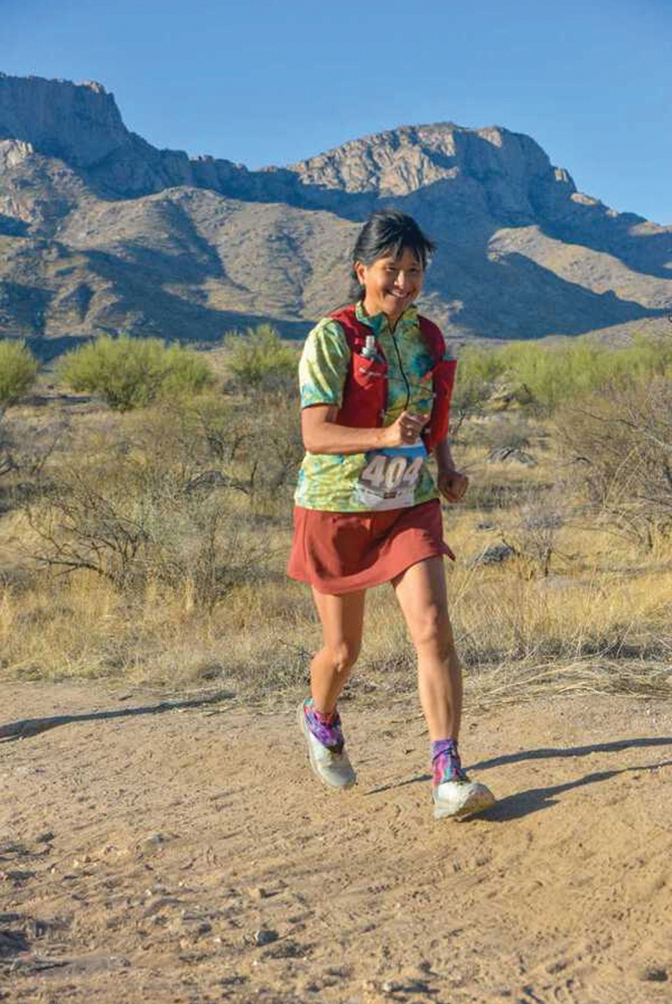 Penelope Wong is running with mountains behind her.