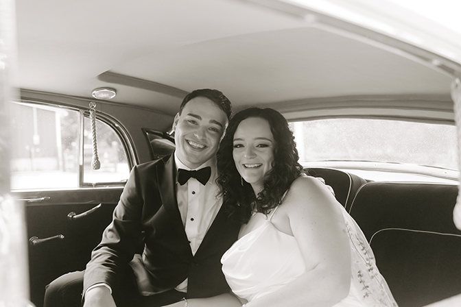 Photo of Chloe Conn and Conner Johnson sitting in a car with their tux and wedding dress on.