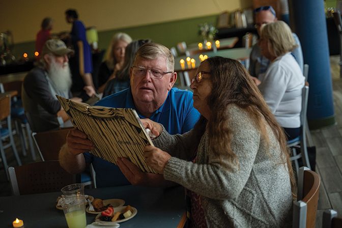 Two alumni look at an old yearbook together