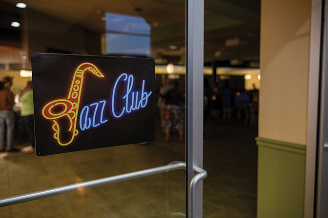Photo of a light up sign that says "Jazz Club" that is attached to the doors of Baird Lounge