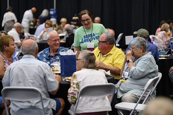 Berea Alumni Philanthropy employee greets alumni at the indoor class reunion picnic