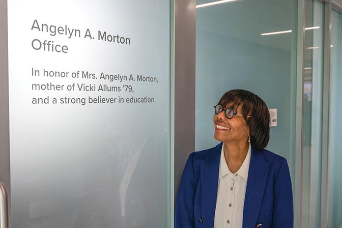 Foundations of a Life Vicki Allums ’79 stands in front of a glass door with her mother's name on the office it leads to.