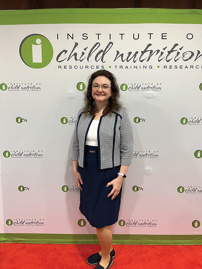 Portrait of Terina Hoskins Edington standing in front of a child nutrition backdrop.