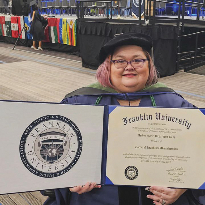 Photo of Amber Richardson holding up her degree from Franklin University.