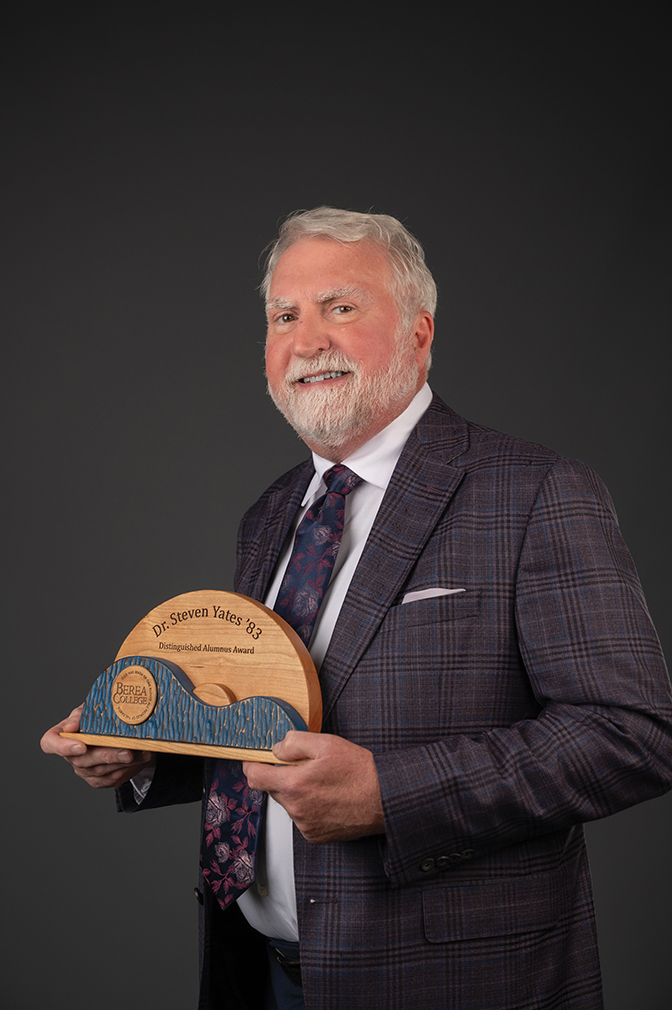 Portrait of Steven Yates holding his alumni award