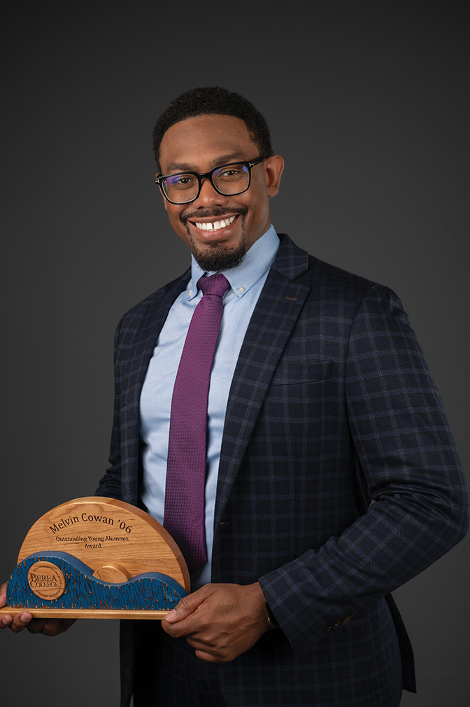 Portrait of Melvin Cowan holding his alumni award.