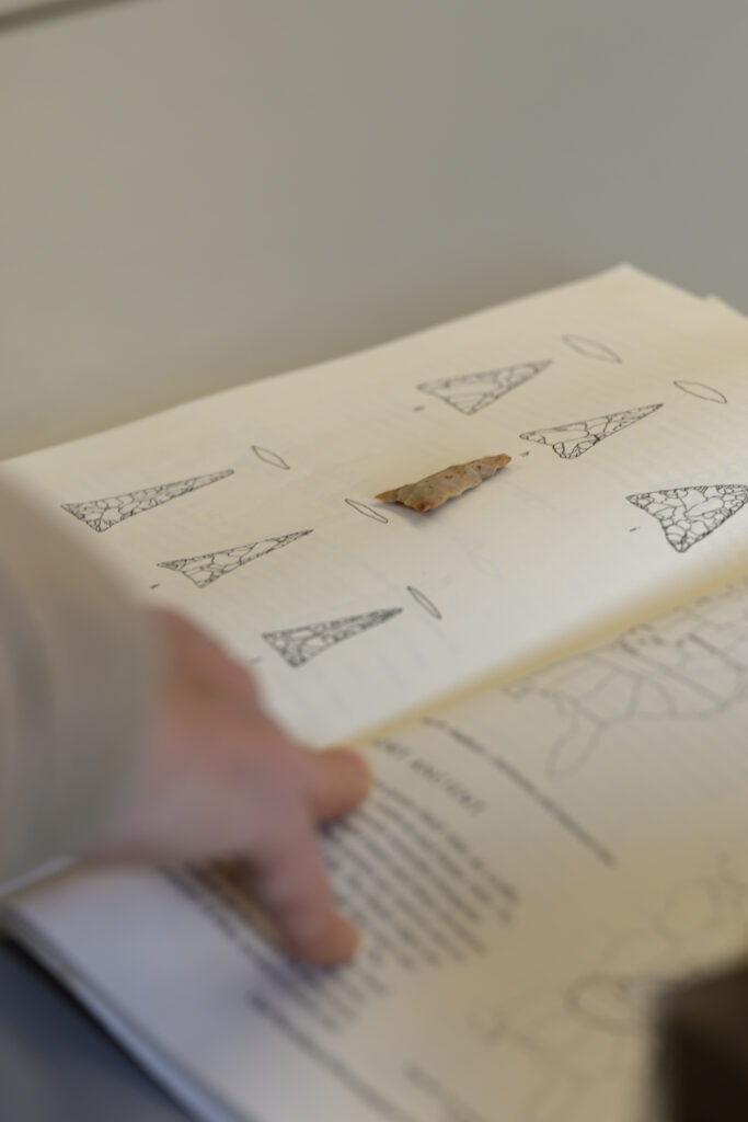 An arrowhead laying on top of a book.