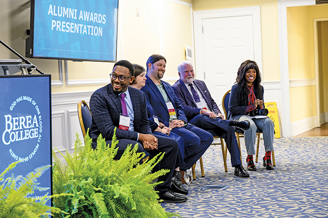 Alumni Awards – Homecoming 2025 The 2025 Alumni Award winners sitting in a row at the Alumni Awards ceremony, laughing.