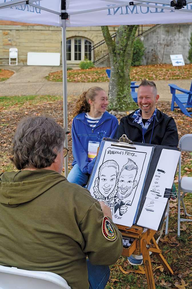 An alumnus and his daughter enjoy having their portraits sketched by a cartoonist.