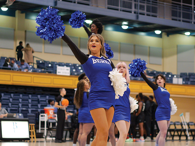 A cheerleader leads the crowd during a floor cheer at the homecoming game.