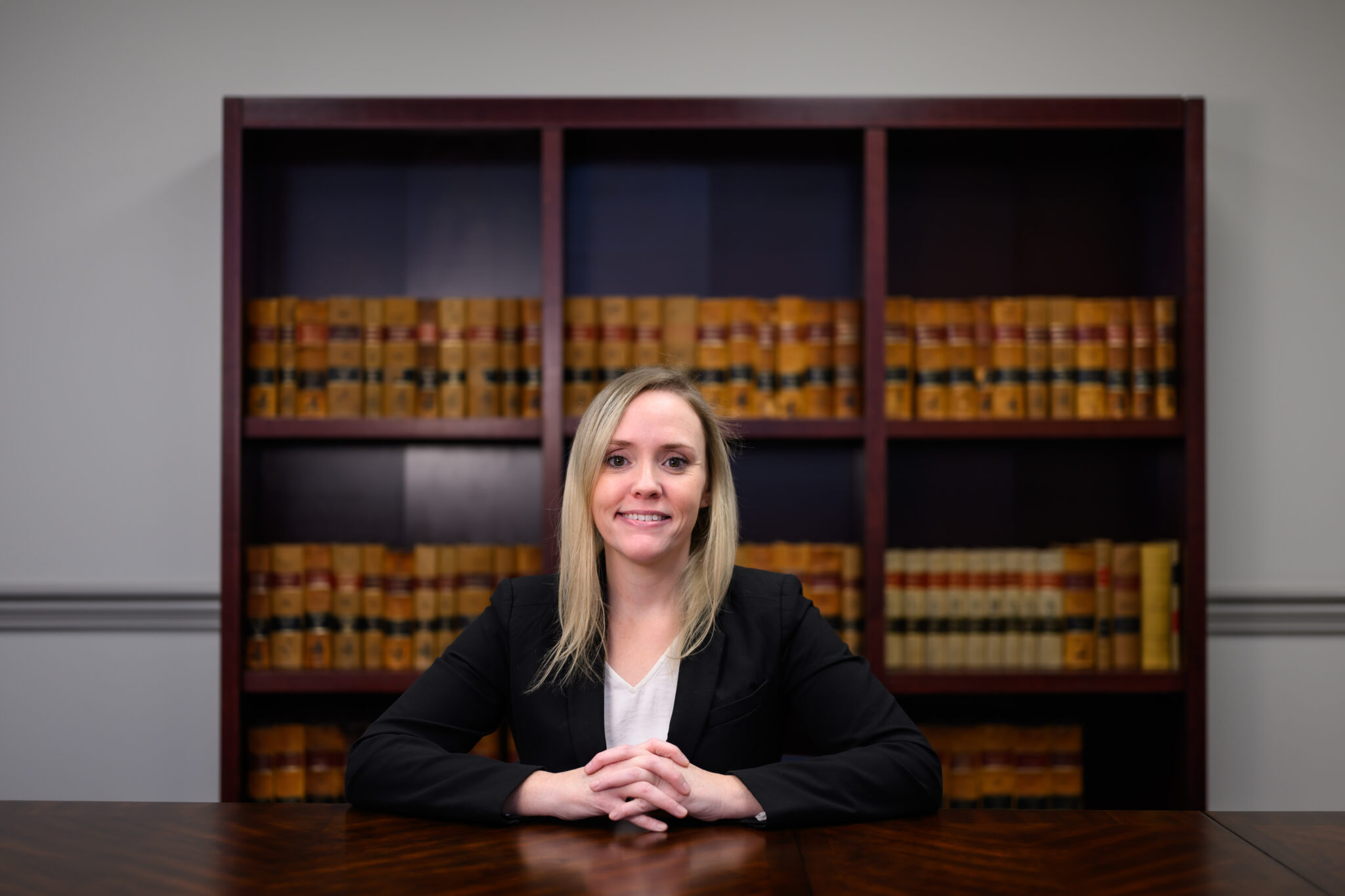 From the Shadows to the Statehouse Portrait of Linsey Hogg sitting in front of a shelf of law books