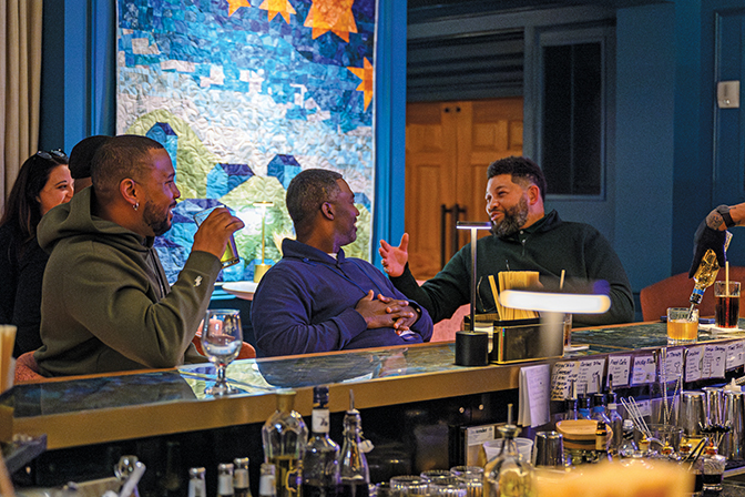 Three alumni share a drink and catch up in Boone Tavern's Crafted bar area.