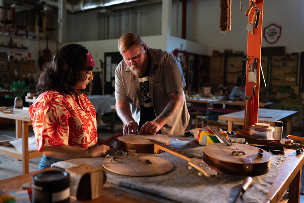 Rob Spiece looking over banjo in a workshop.
