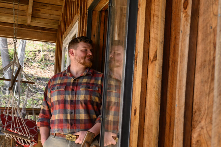 Building a Community of Writers Portrait of Matt Parsons '15 looking through the door of his home.
