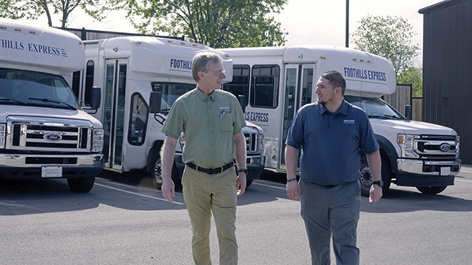 Tyler Burris ʼ13 and Joe Wilkie ʼ90 stand in front of the organization's fleet in Richmond, Ky. 