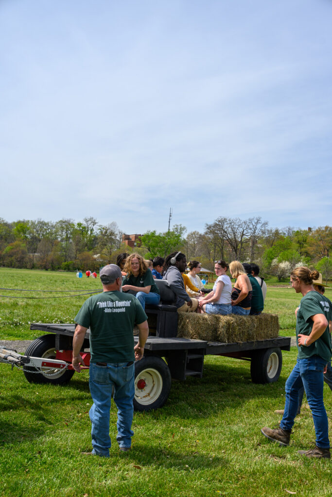 Students loading onto a tractor for a hay ride in Alumni fields