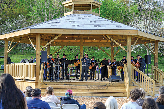 Photo of students singing and playing instruments on the large gazebo stage recently build at Alumni fields.