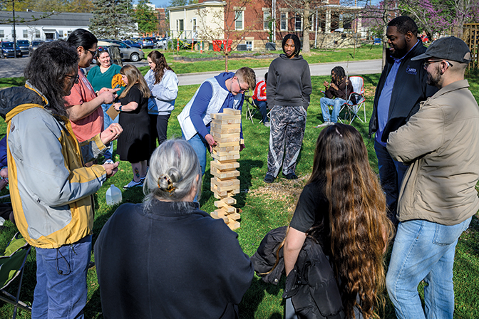 Students and staff gather around a large Jenga game during fields games