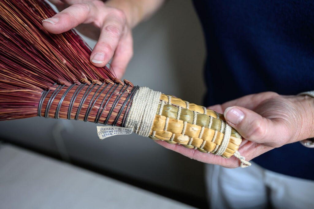 Deloris Reed's hands can be seen showing the details of a broom constructed by her father. 