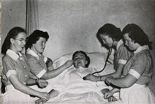 Black-and-white photo from a Berea College Chimes Yearbook shows nursing students practicing while another student poses as a patient.